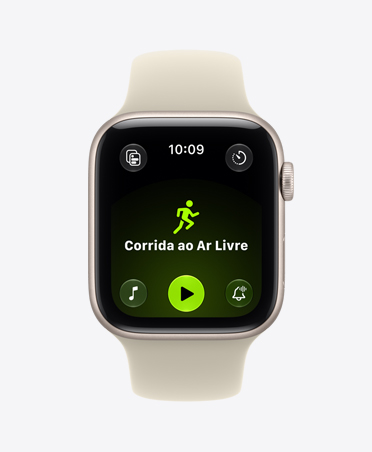 Apple Watch SE 3 com caixa estelar de alumínio e pulseira esportiva na cor areia (bege-pálido). A tela mostra o app Exercício (corrida ao ar livre). Digital Crown no lado direito.