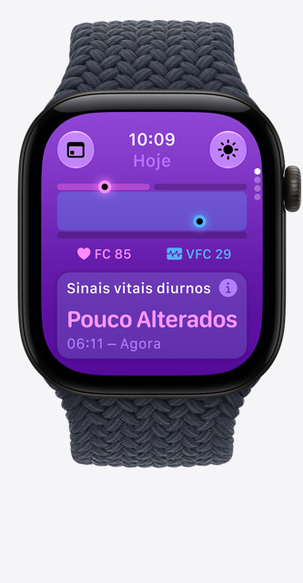 Apple Watch Series 12 com caixa preta de alumínio e pulseira loop solo trançada azul-marinho. O app Sinais Vitais mostra um gráfico de pontuação de saúde, a frequência cardíaca atual em batimentos por minuto e uma leitura durante o dia indicando sinais vitais levemente alterados