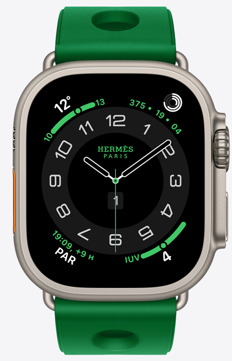 Apple Watch Hermès Ultra 4, cadran analogique Circulaire (aiguilles pour les heures, les minutes et les secondes, complications : météo, anneaux d’activité, heure de Paris, indice UV), boîtier en titane, couleur naturel, face latérale droite, couronne Digital Crown, bouton latéral surélevé, jumelée au bracelet Scub’H Diving, couleur vert vertigo (vert vif), caoutchouc moulé, découpes circulaires centrées
