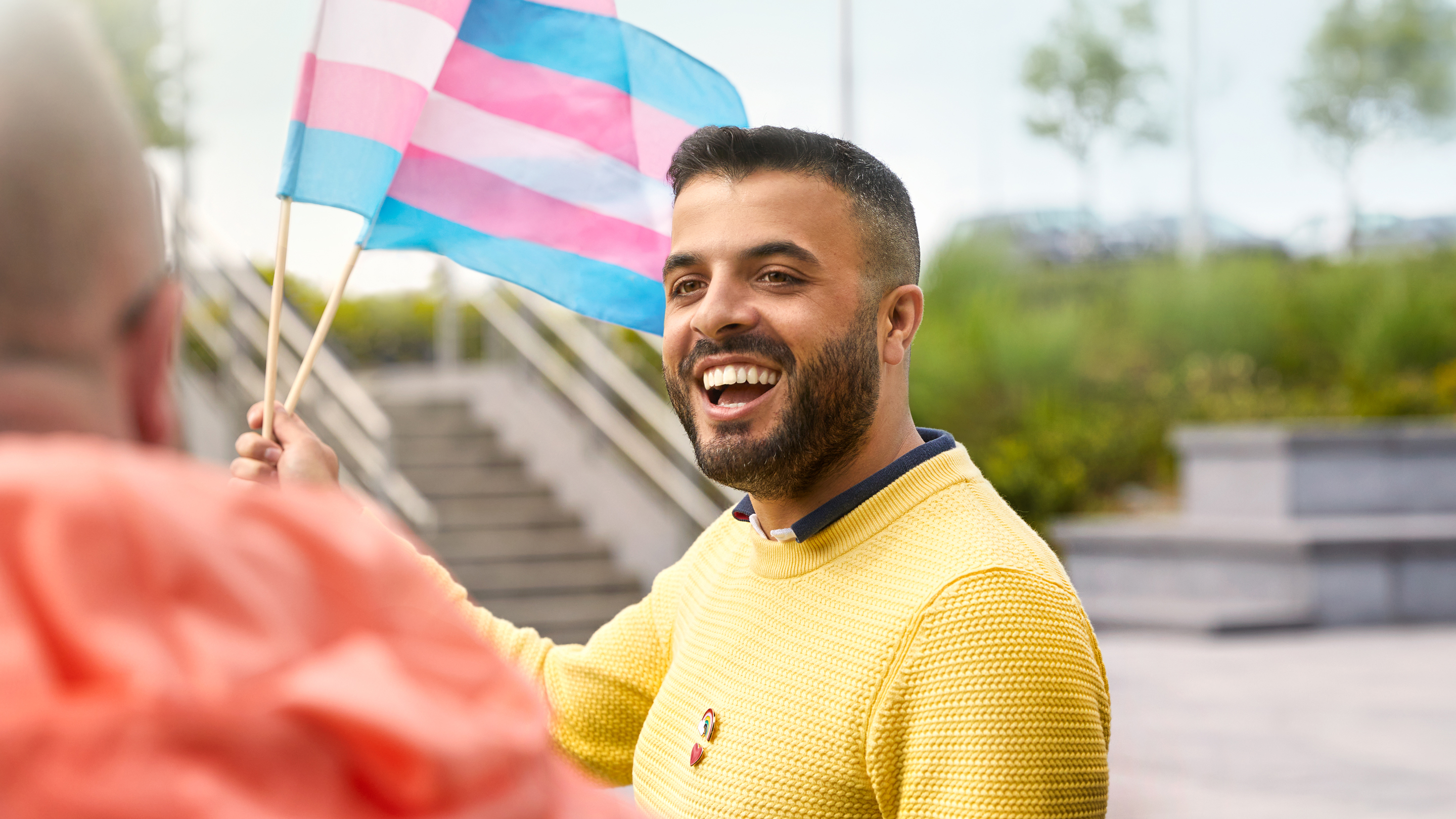 Membre de l’équipe Apple à Cork brandissant un drapeau de la communauté trans.