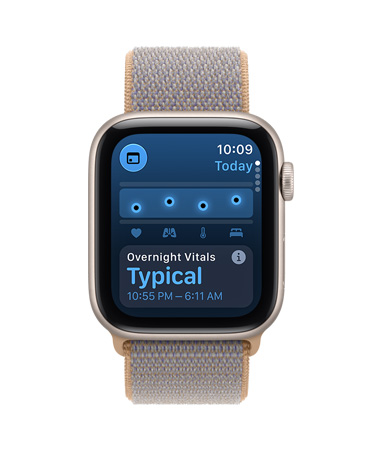 Apple Watch SE 3, na displeji noční životní funkce, hliníkové pouzdro, hvězdně bílá barva, na pravém boku korunka Digital Crown, sportovní řemínek, barva šambré (světle modrošedá)