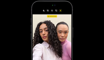 iPhone 18 Pro noir, de face, montrant deux personnes avec la fonctionnalité de suivi des visages, présentant la caméra avant Center Stage