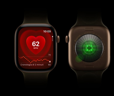 Due Apple Watch Series 12 affiancati; l’Apple Watch Series 12 a sinistra è mostrato di fronte e sul display si nota il rilevamento della frequenza cardiaca; l’Apple Watch Series 12 a destra è mostrato da dietro e si notano le luci verdi che brillano