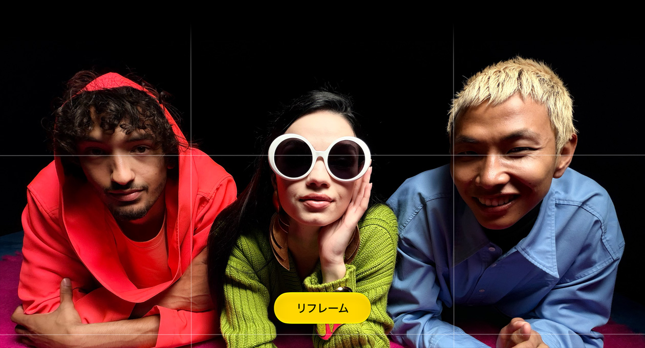 カメラを見つめる3人の人物を撮影した明るい色合いのクローズアップ写真。「リフレーム」というボタンが表示されている