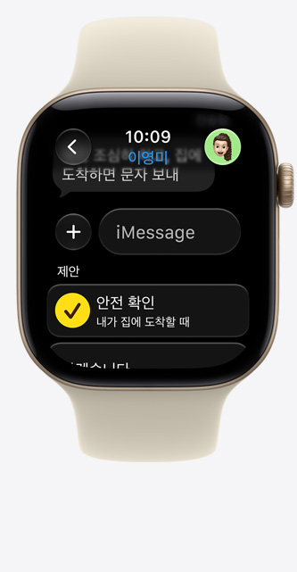 라이트 골드 색상 알루미늄 케이스의 Apple Watch Series 12. iMessage에 '안전 확인' 제안이 표시되어 있고 샌드 색상(연한 탠 계열) 스포츠 밴드를 장착