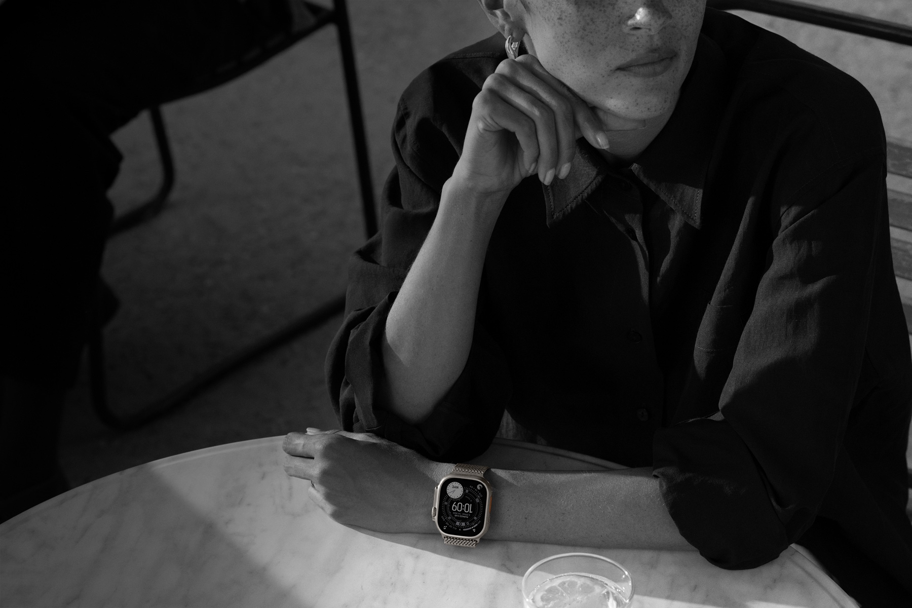 O persoană poartă Apple Watch Ultra 3 în timp ce ia cina în oraș