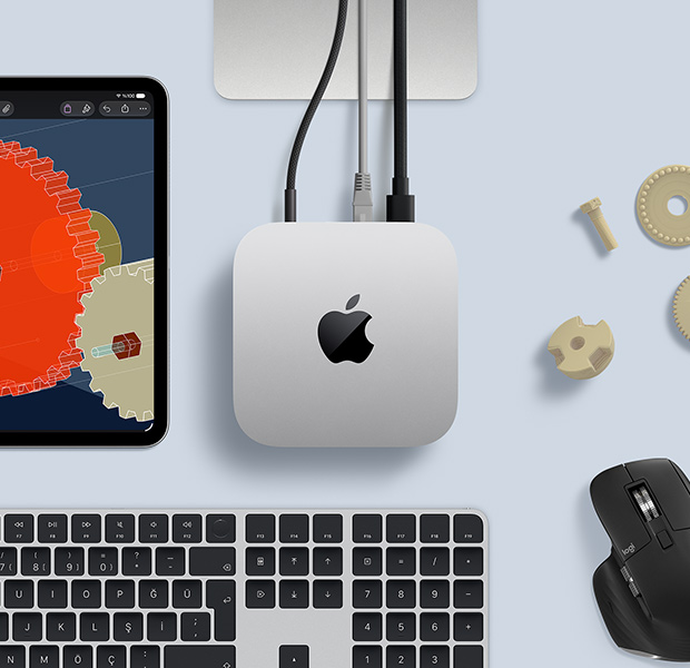 STEM dallarıyla ilgili detaylı nesnelerin gösterildiği iPad, güç kablosunun bağlı olduğu Mac mini ortada duruyor, Studio Display standının kısmi görünümü, USB-C ile bağlı, Touch ID özellikli Magic Keyboard ve Logitech mouse