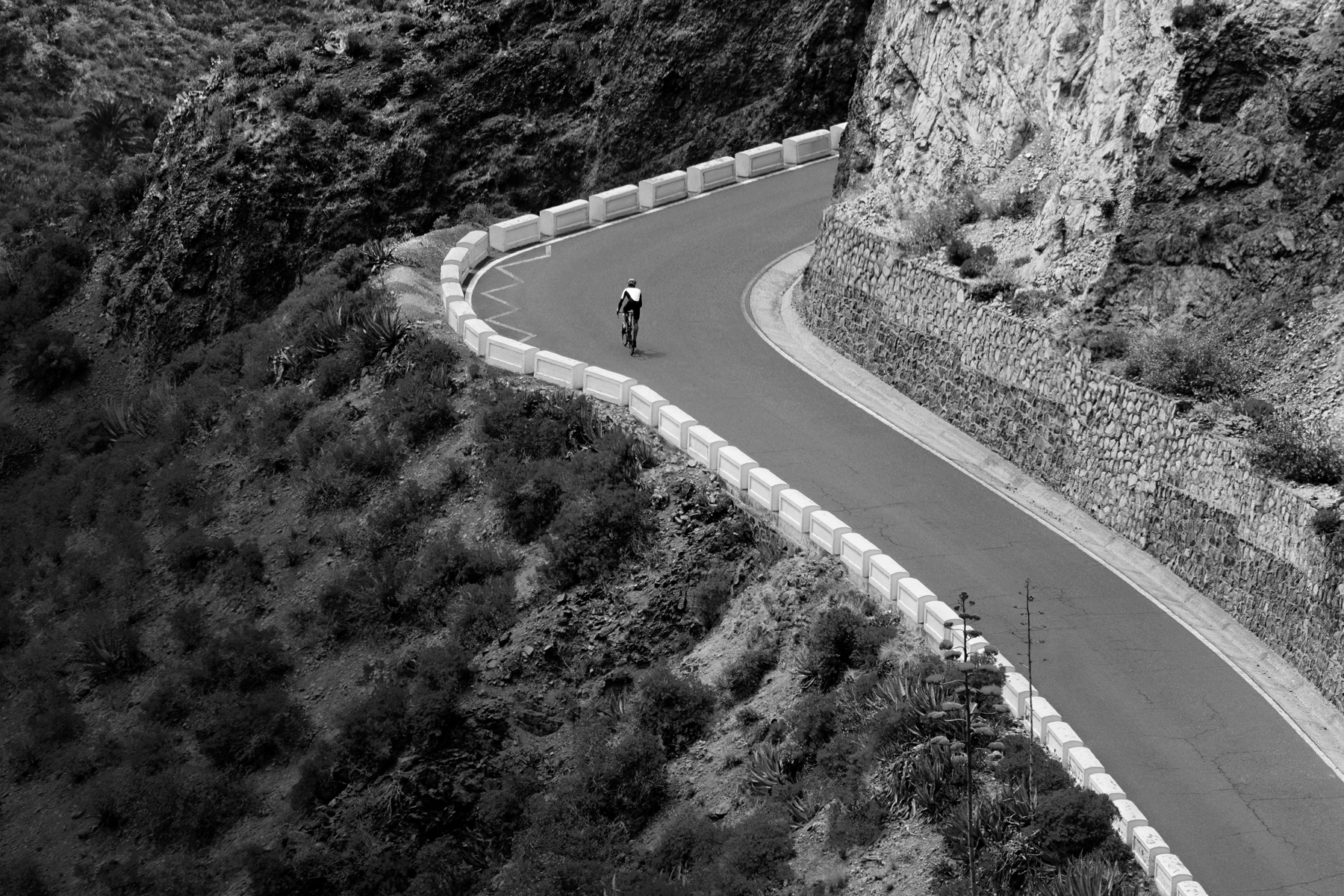 A cyclist bikes up a mountain road