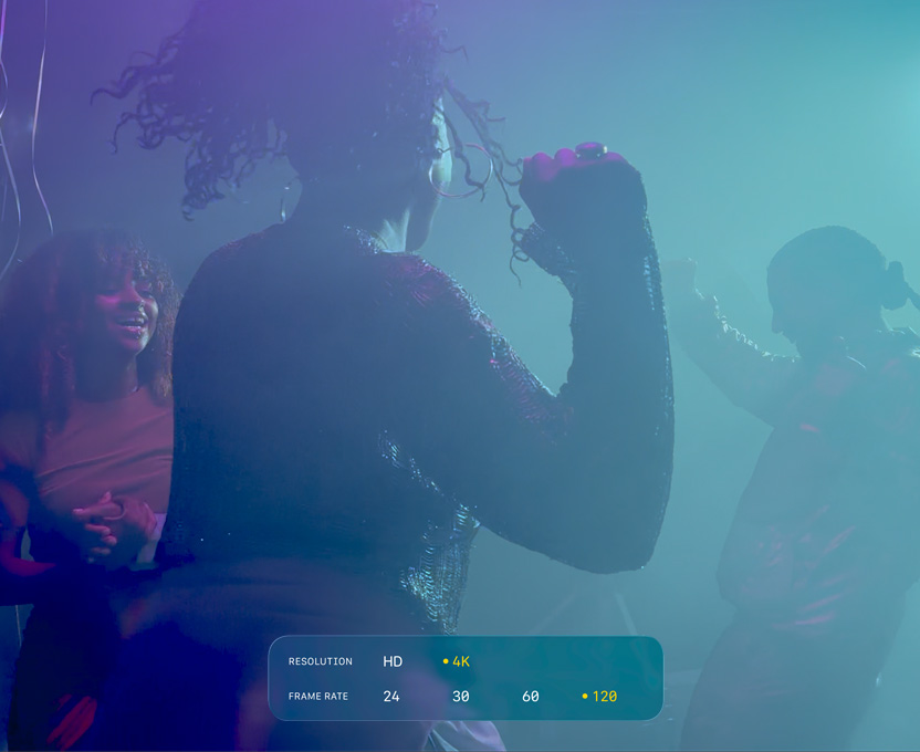 Un écran affichant trois personnes en train de danser dans l’obscurité illustre les capacités du format Dolby Vision 4K à 120 i/s
