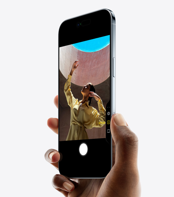Ranka, laikanti „iPhone Air“ su nykščiu ant kameros valdiklio mygtuko, priekinė pusė, šoninė pusė, plonas profilis, „Dynamic Island“, šoninis mygtukas